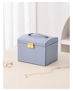 Close-up of light blue leather jewelry box with elegant gold clasp and handle