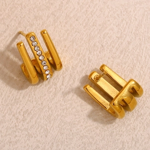 Three-row golden J-hook stud earrings with sparkling cubic zirconia on textured background