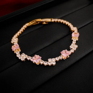 Detail of gold bracelet with pink square zircons and micro-pave crystals in box