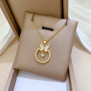 Elegant gold titanium steel necklace with crystal butterfly pendant on a beige cushion