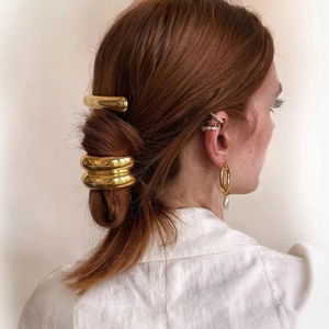 Close-up of minimalist 18k gold-plated U-shaped hair rings and pearl drop earrings