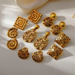 Detailed view of assorted 18k gold geometric stud earrings with leopard print patterns
