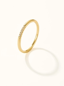 Detail shot of a slim gold band ring featuring small zircon stones in a minimalist design