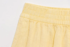 Détail du short en coton et lin jaune montrant la taille élastique et la texture du tissu