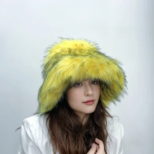 Detail shot of oversized fluffy yellow faux fur bucket hat with black tips for winter