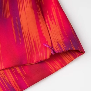 Detailansicht des versteckten Reißverschlusses am orange-fuchsia gestreiften Rock