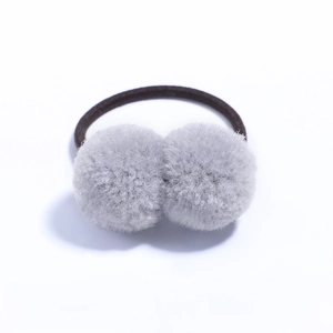 Detail view of two gray plush pompom hair ties with high elasticity black rubber bands