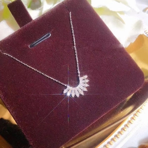 Collier élégant avec pendentif en éventail et zircons sur fond de velours rouge