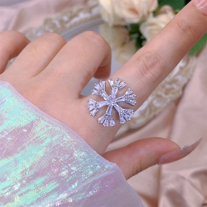 Detail of a sparkling silver snowflake ring featuring multi-faceted zircon inlay
