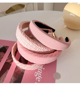 Dettaglio di cerchietti in tessuto rosa con texture a righe, pieghe e trama