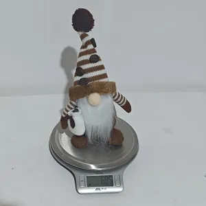 Detail shot of a khaki coffee gnome ornament being weighed on a scale at 68.5g