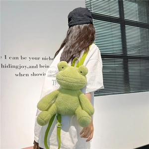 Cute green plush frog backpack for women shown on model in a soft natural light setting