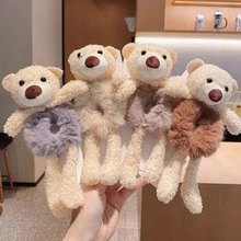 Detailed view of four soft plush bear hair ties in purple, beige, and brown colors