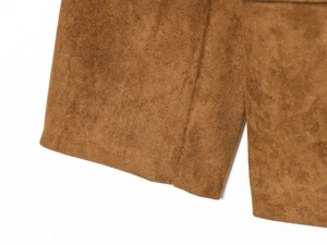 Close-up of brown suede fabric texture and cuff detail on a stylish western blazer