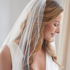 Detail of bridal veil featuring handmade beaded tassels and rhinestones on soft ivory tulle