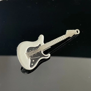 Detailed close-up of a Y2K style guitar hair clip with black and white enamel finish