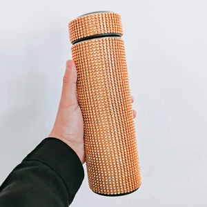Close-up of sunset gold rhinestone-encrusted smart flask with sparkling crystals