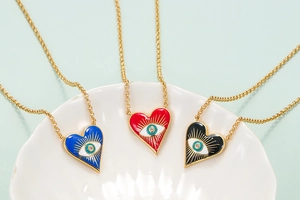 Detail of colorful enamel heart evil eye pendants with sparkling center rhinestones