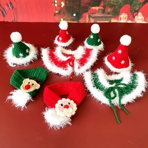 Flat lay of red and green knitted Christmas hats and scarves for cats and dogs