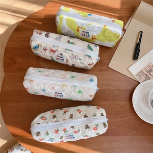 Detailed view of quilted cotton pouches featuring duck, dog, and floral print patterns