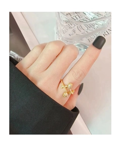 Detail of a gold tulip bypass ring with sparkling zircons worn on a model's finger