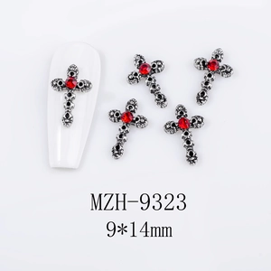 Macro shot of 9x14mm Gothic silver cross nail charm with red rhinestone center