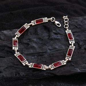 Silver chain bracelet with rectangular red crystals and zircon accents on black stone