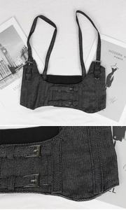 Detail of adjustable shoulder straps and double metal buckles on dark grey denim corset belt