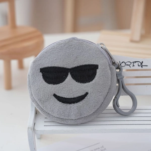 Close-up of grey plush coin purse with embroidered sunglasses smiley and plastic hook