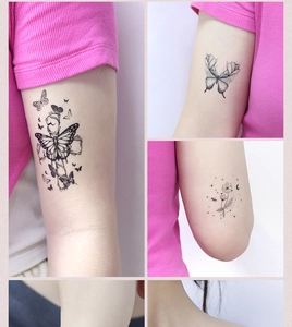 Close-up of minimalist black butterfly and floral temporary tattoo designs on skin