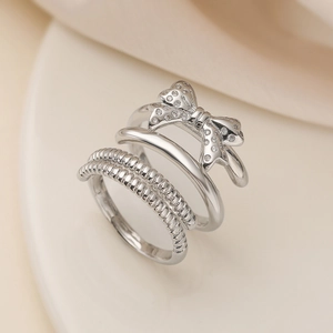 Macro detail of silver layered ring featuring a zircon bow and textured bands