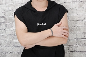 Close-up of men's silver wheat chain bracelet and ring set on punk style outfit