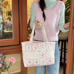 Close-up of quilted cotton tote bag featuring delicate floral prints and bow details