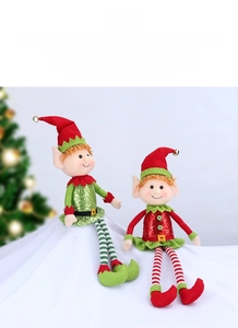 Close-up of long-legged Christmas elf dolls with sequins and bells in a snowy scene