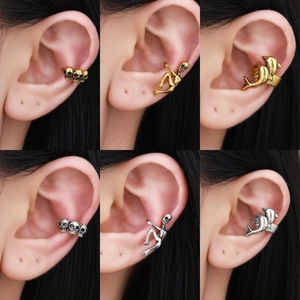 Gothic ear cuff set featuring skull and spider motifs in silver and gold metal finishes