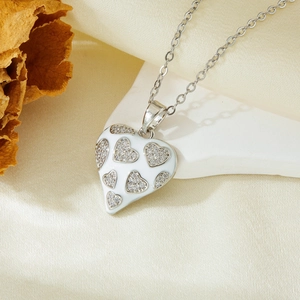 Close-up of heart-shaped silver pendant necklace with white enamel and micro-set zircons