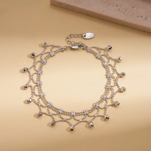 Detail of multi-strand silver beaded chain necklace with faceted drop pendants