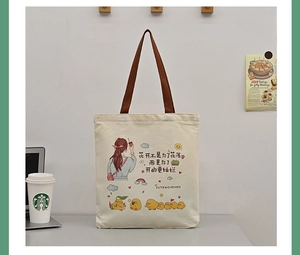 Detailed shot of beige canvas tote bag with colorful girl and chicken illustration