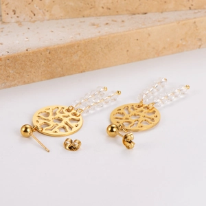 Macro detail of gold dreamcatcher earrings with transparent beads and stone accents