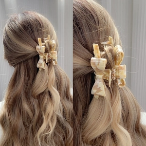 Elegant bow-shaped acetate hair claw with cream marble texture for women hair styling