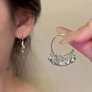 Silver hoop earrings with beaded tassels in vintage ethnic style worn on ear
