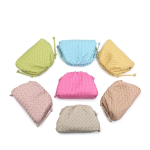 Woven leather clutch bag detail showcasing intrecciato design and vibrant pastel color options.