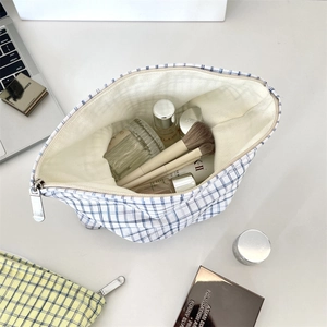 Top view of open checkered cosmetic bag with silver zipper showing large inner capacity