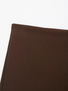 Close-up of deep brown asymmetric skort fabric showing dense canvas texture and weave