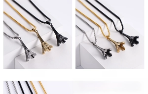 Detailed view of Eiffel Tower necklaces in silver, gold, and black finishes on white blocks