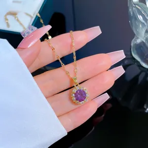 Macro detail of gold-plated sunflower pendant with purple stone and pave crystals