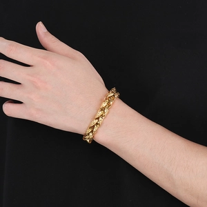 Dettaglio del bracciale punk da uomo dorato con texture martellata sul polso