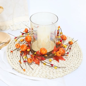 Autumn harvest candle ring featuring artificial pumpkins, maple leaves, and berries on a tray