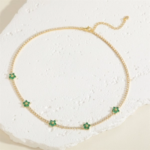 Close-up of golden floral choker with green zircon petals and adjustable lobster clasp