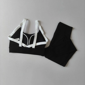 Flat lay detail of black yoga set featuring cross-back sports bra and high-waisted leggings